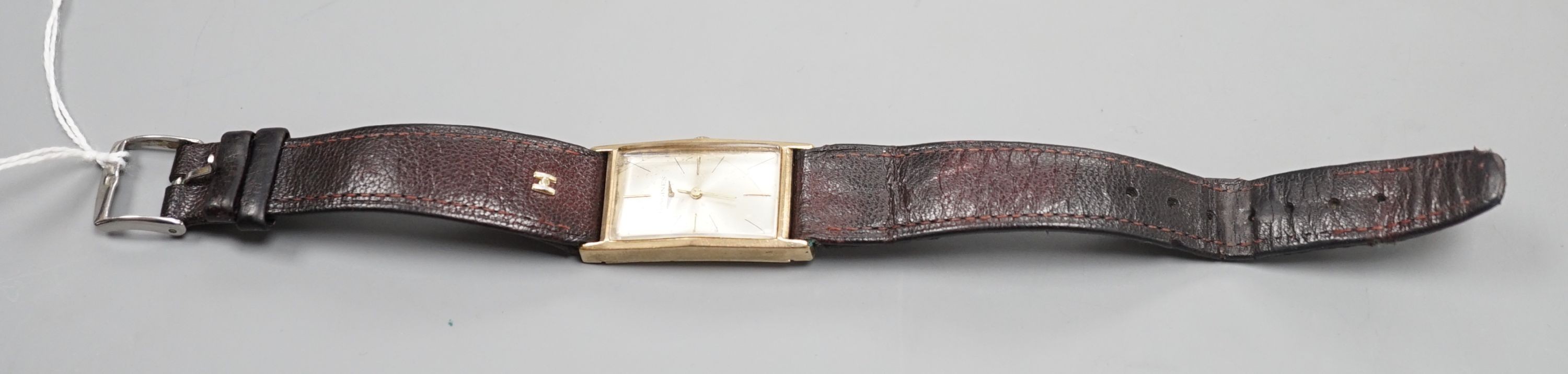 A gentleman's 14k Longines manual wind rectangular dial wrist watch, case diameter 20mm, on associated leather strap.